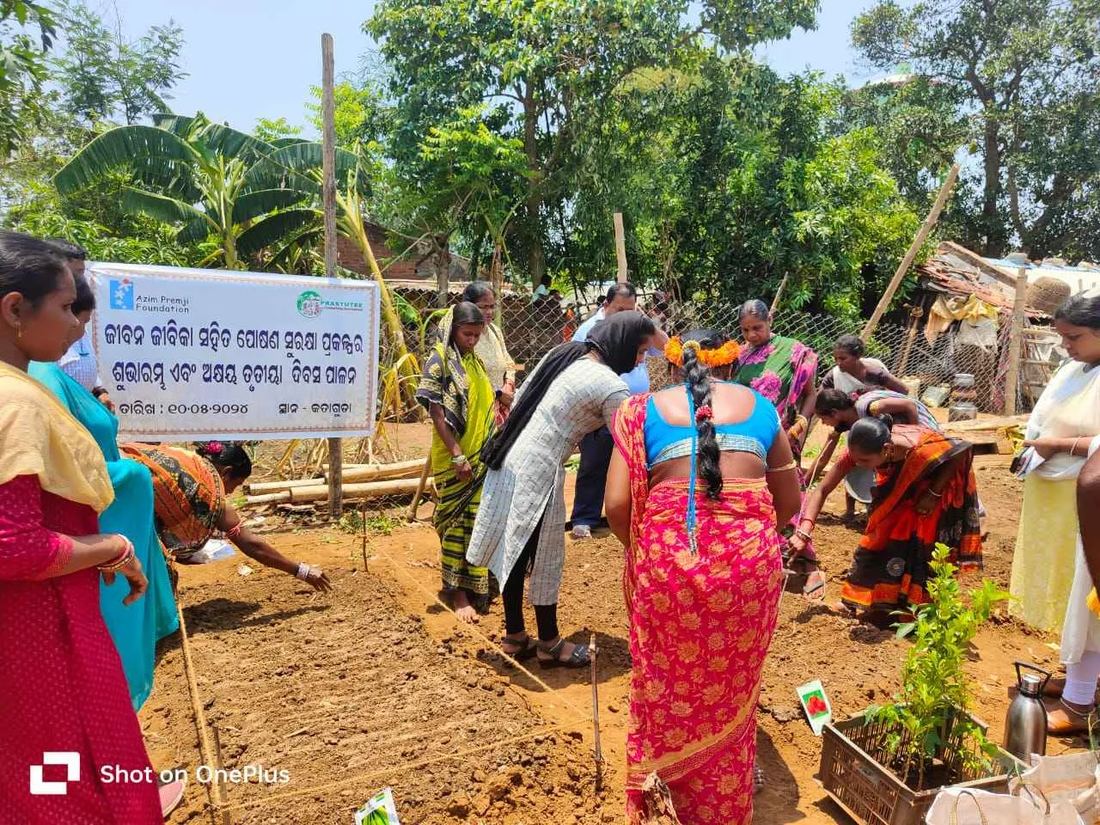 Women laying out kitchen-garden beds at a community event